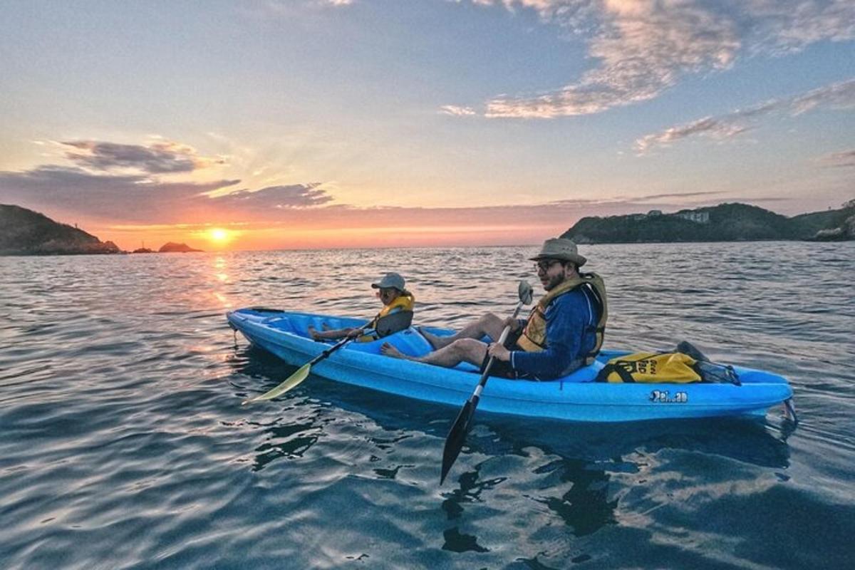 dua orang dalam kayak di dalam air pada waktu matahari terbenam