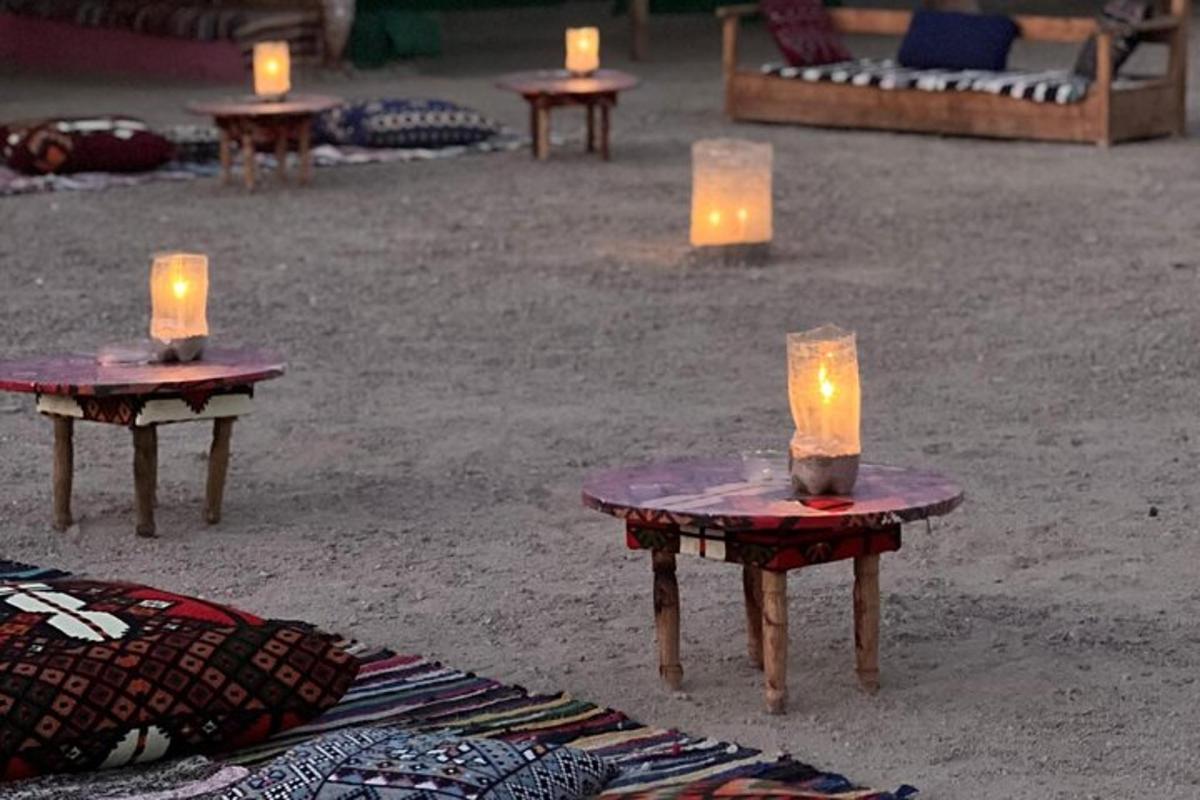 dua lilin duduk di atas meja di pasir