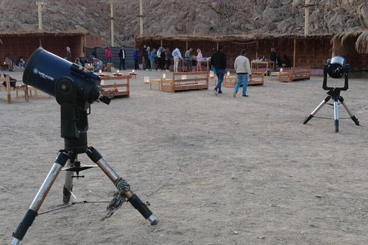 two cameras in a field with people walking around