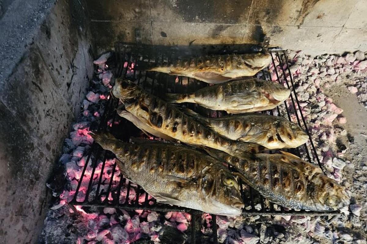 sekumpulan ikan sedang memasak di atas panggangan