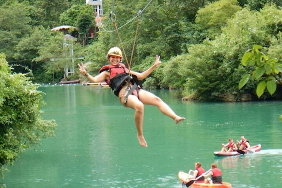uma mulher pulando na água de um lago