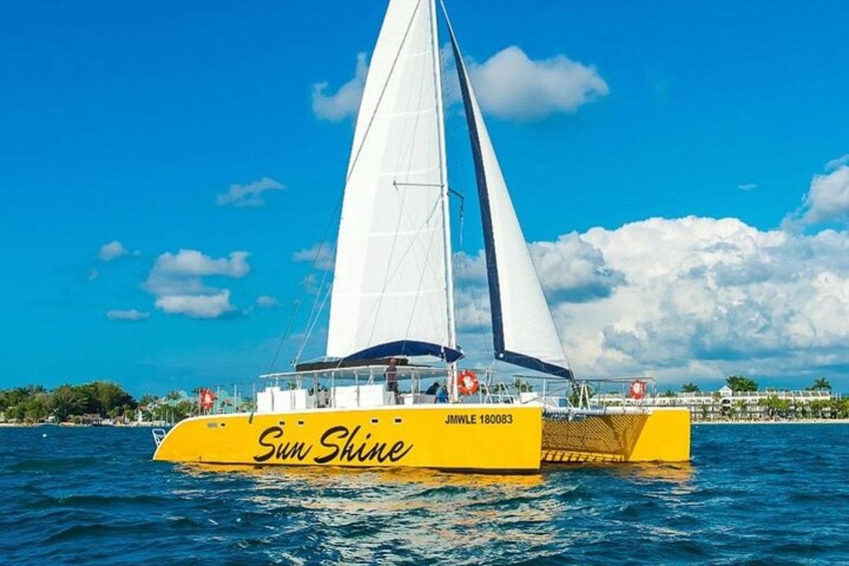 perahu kuning dengan layar putih di atas air