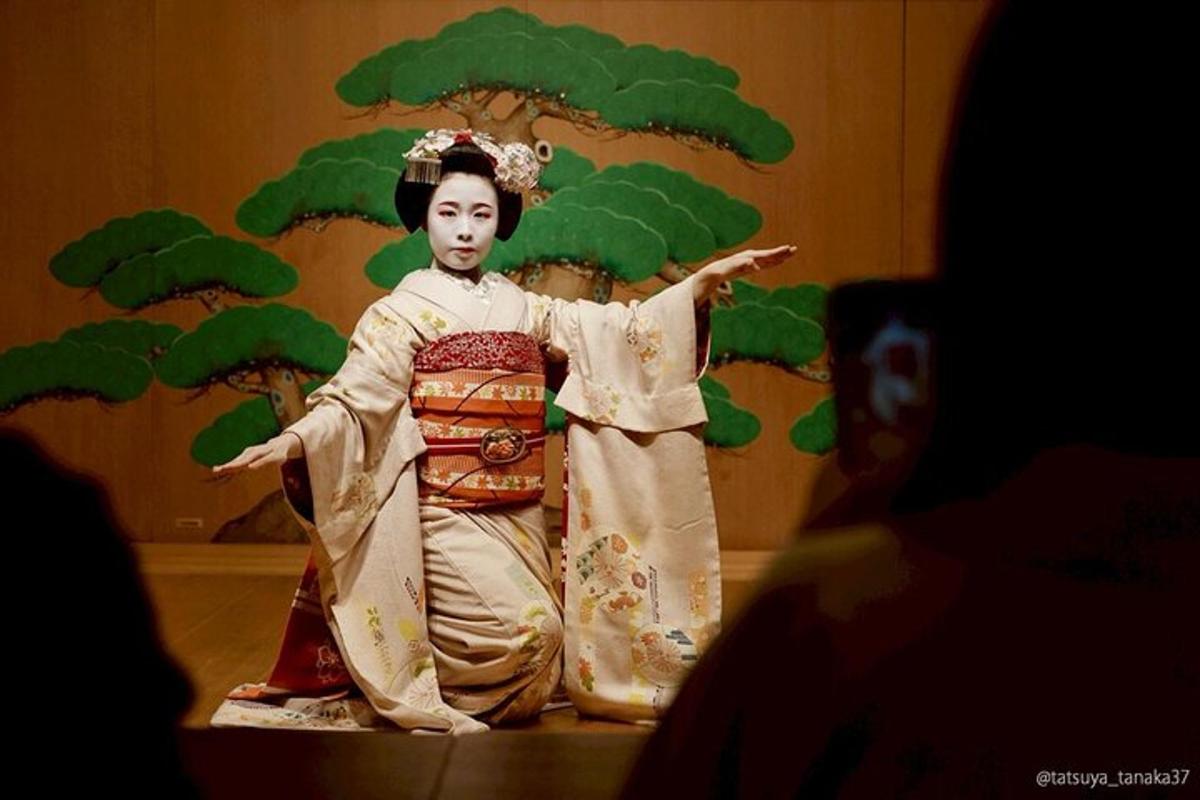 una donna in kimono in piedi davanti a un albero