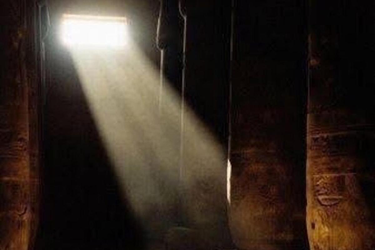 Una luz en una habitación oscura con un pasillo.