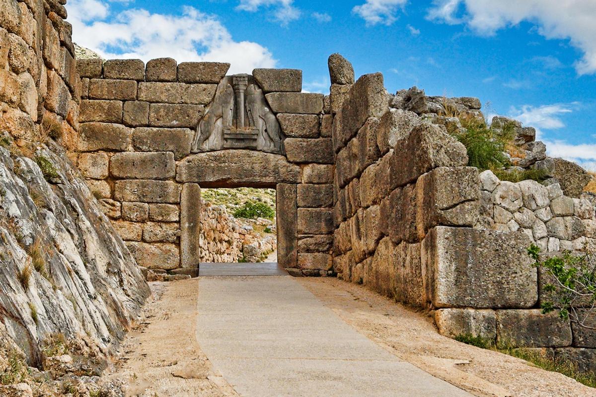 an archway in a stone wall with a pathway