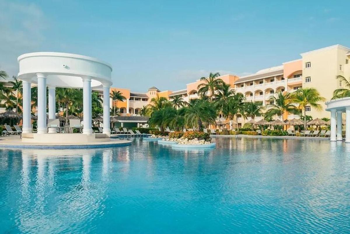 una piscina di fronte a un resort con palme