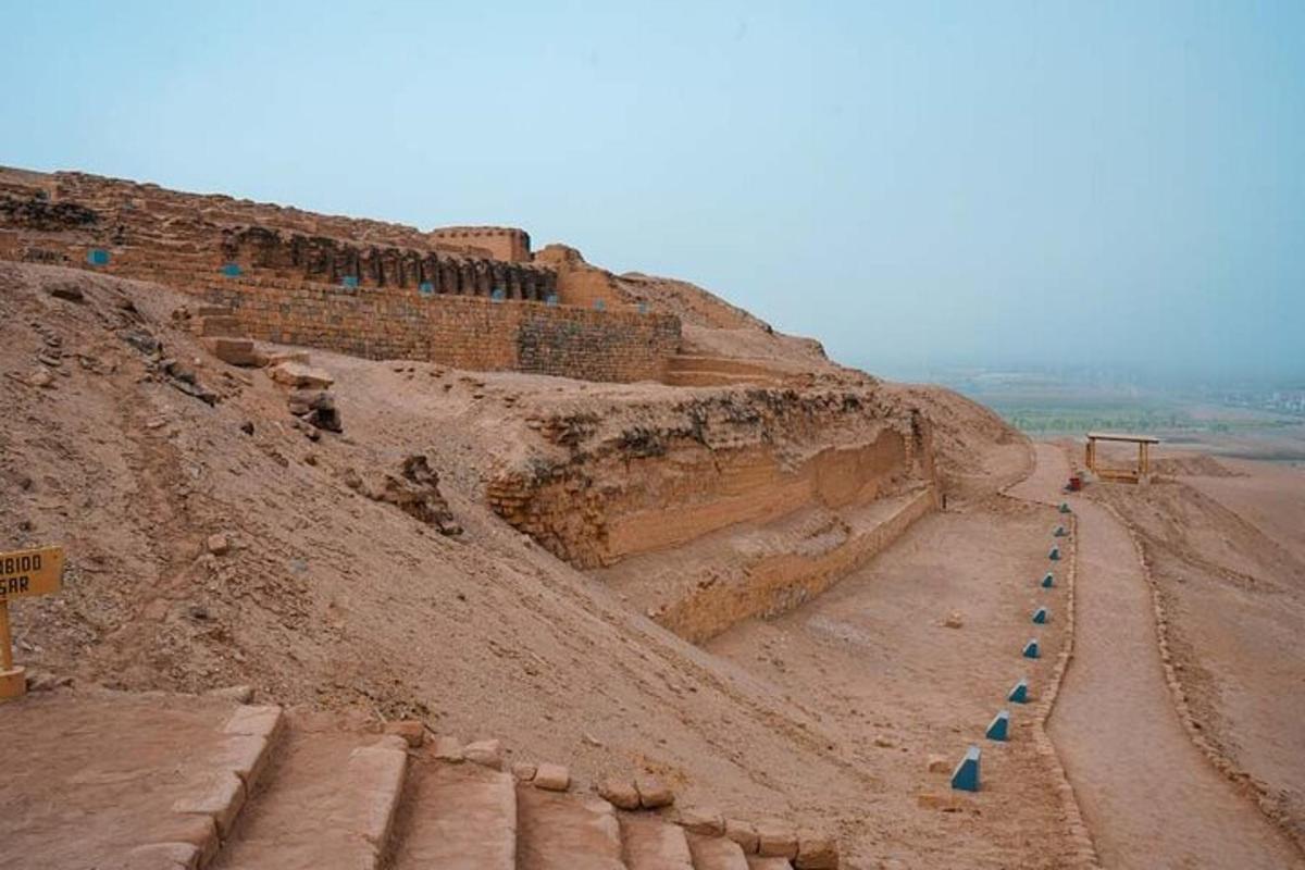 uma encosta de terra com uma estrada e um muro
