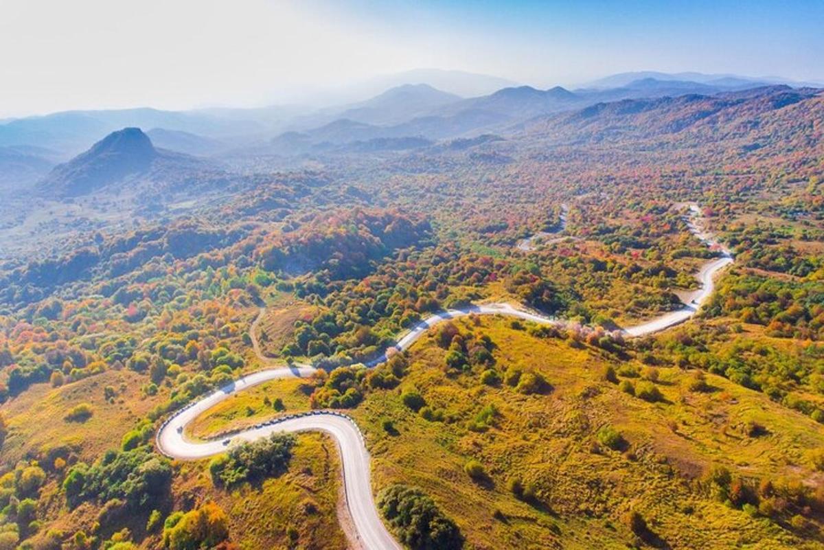 an aerial view of a winding road in the mountains