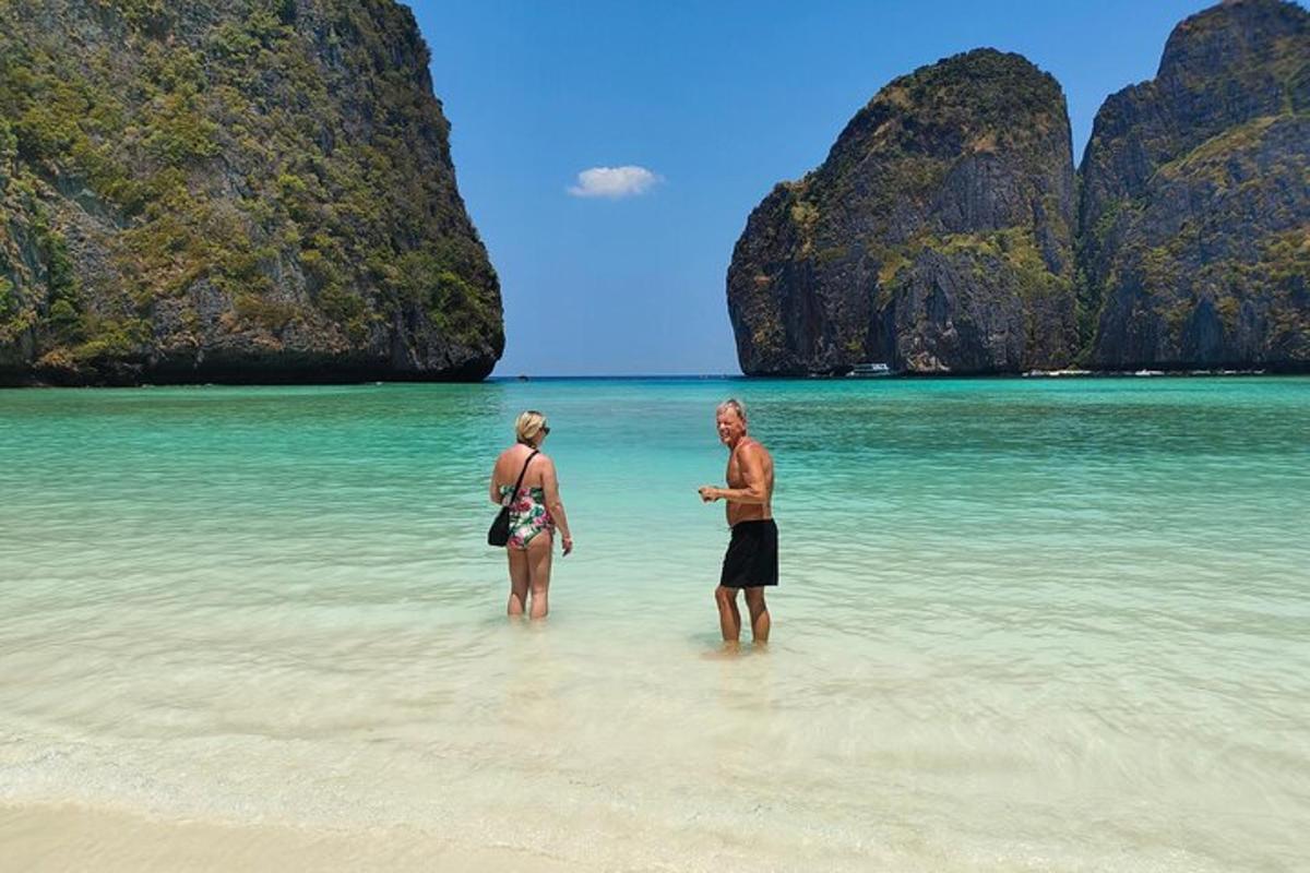 dua orang berdiri di dalam air di pantai