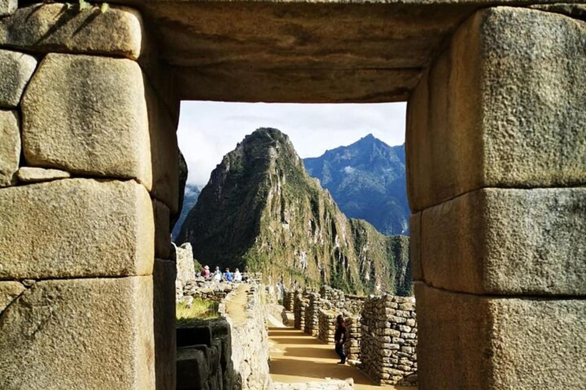 Una vista de una montaña a través de un muro de piedra.