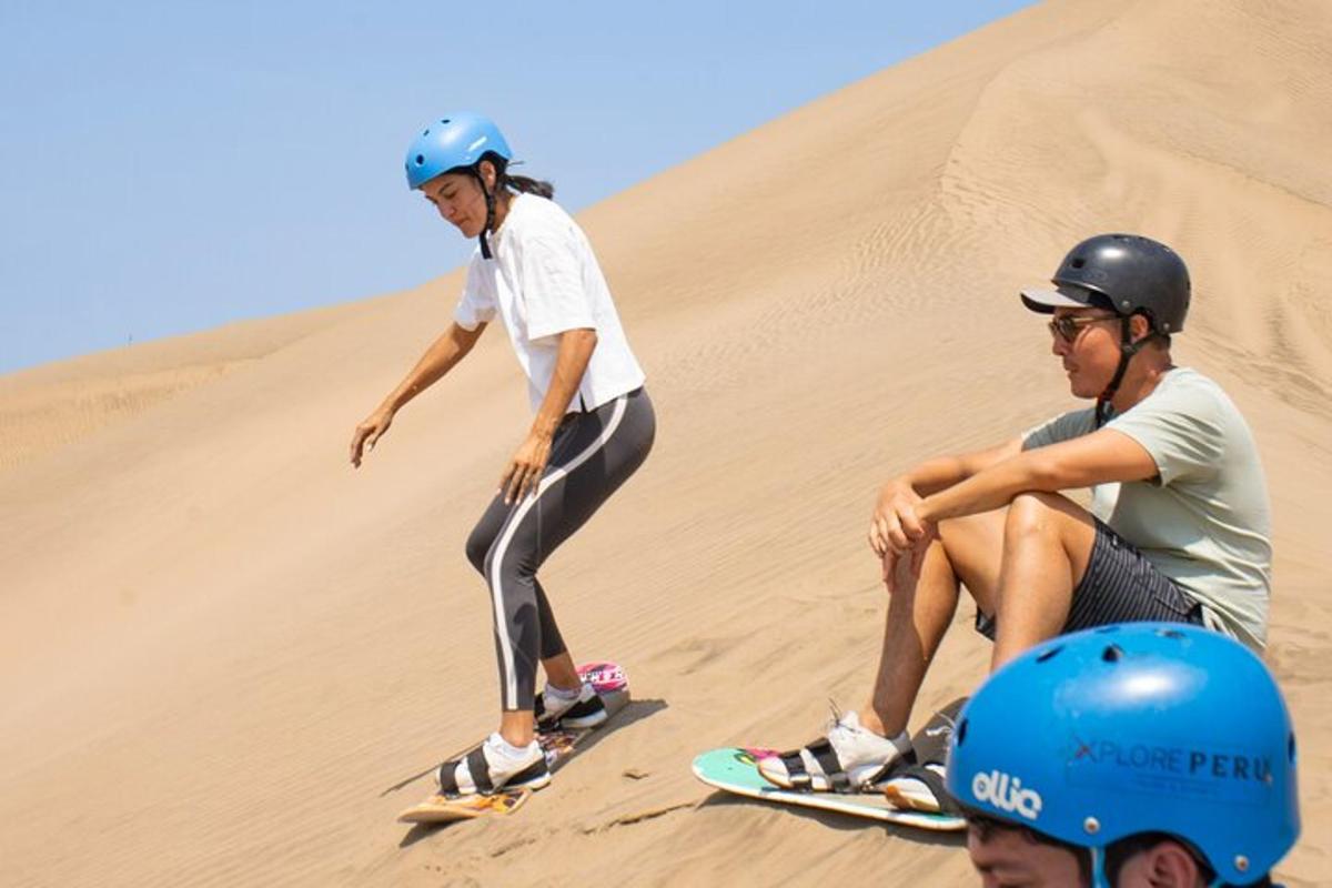 dvaja ľudia jazdiaci na snowboardoch na piesočnej dune