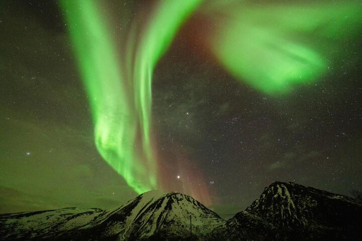 mynd af norðurljósum á himninum yfir fjöllum