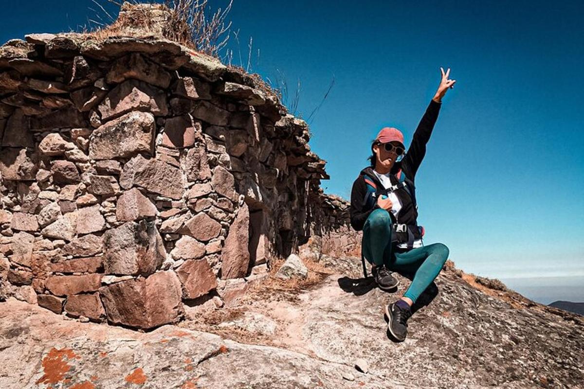 una mujer sentada en la cima de una montaña