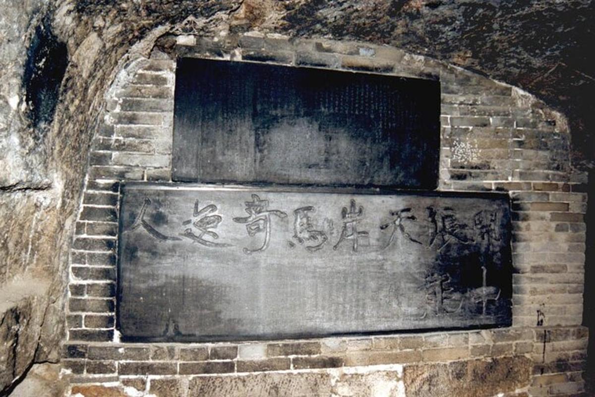 a stone wall with writing on a brick wall