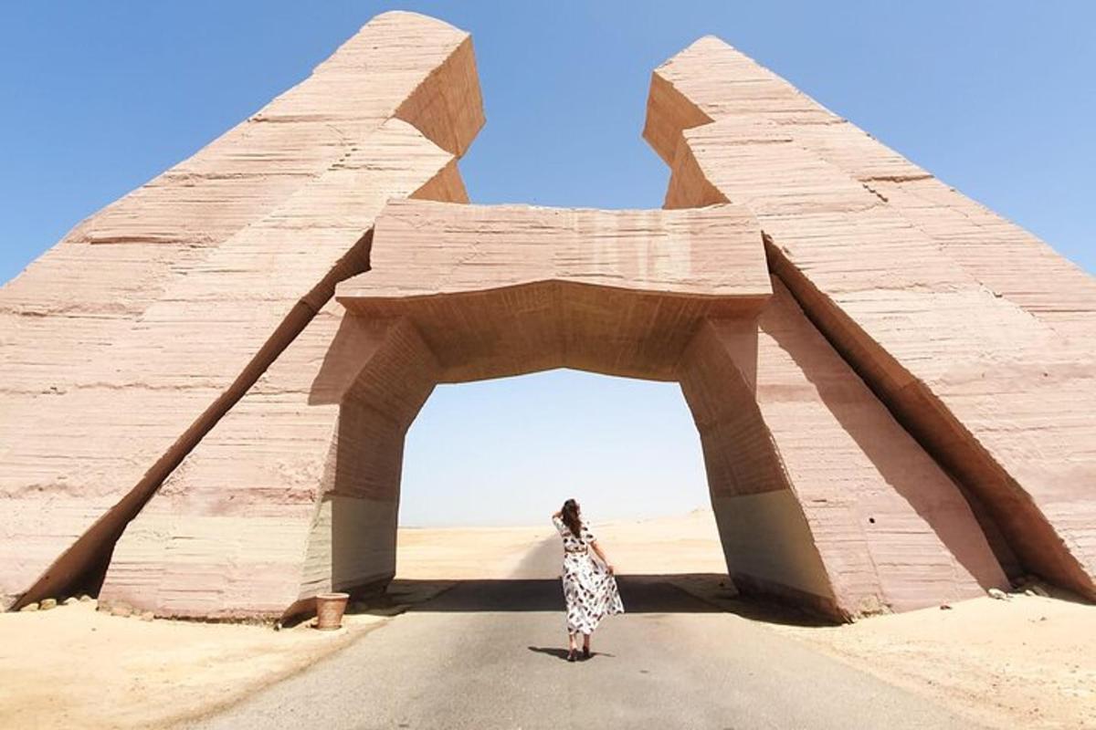 una donna in piedi davanti a un arco nel deserto