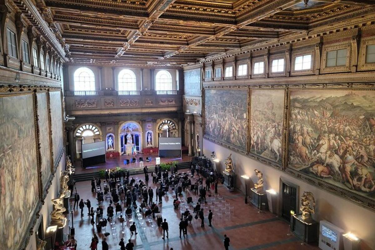una multitud de gent caminant per un museu amb quadres a les parets