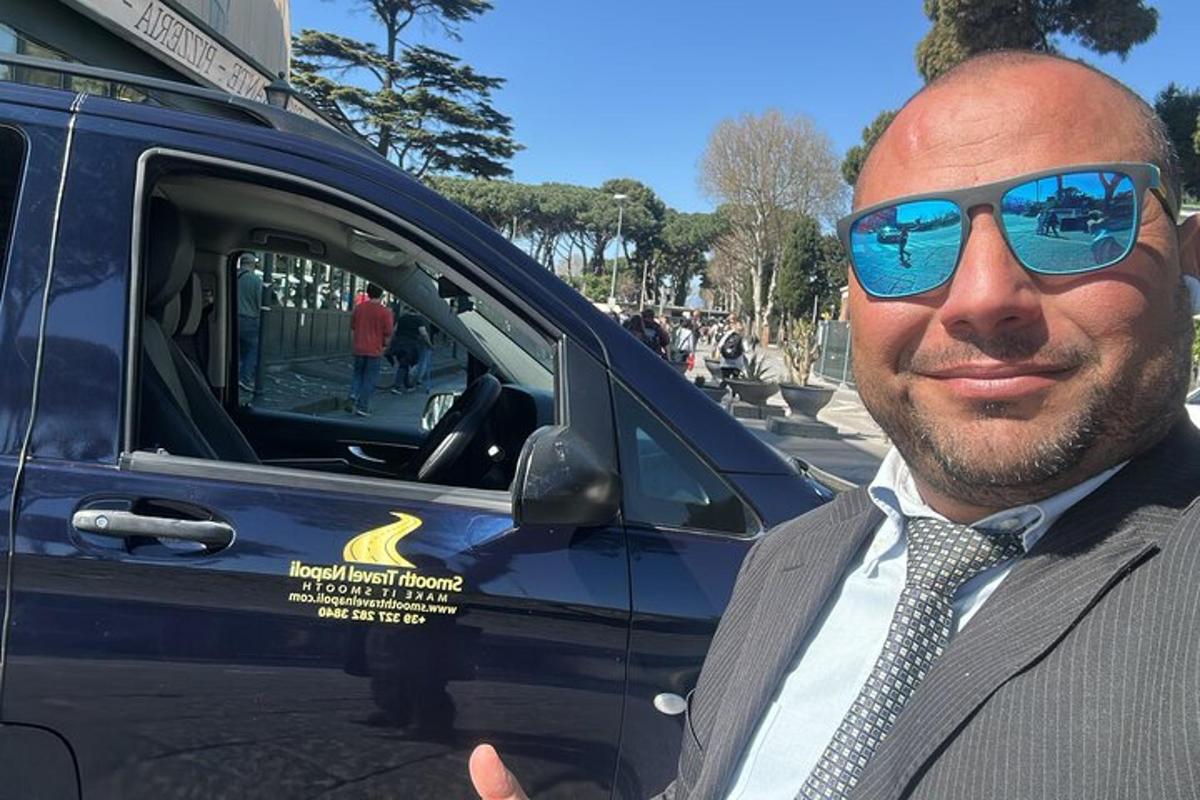 Ένας άντρας με γυαλιά ηλίου στέκεται δίπλα σε ένα αυτοκίνητο