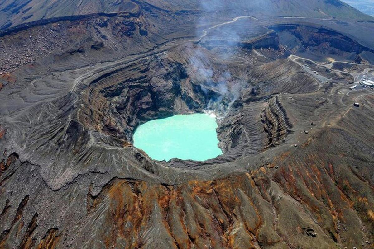 an aerial view of a mountain crater with a blue lake