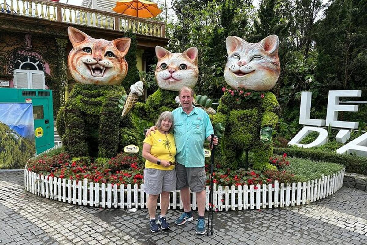 ein Mann und eine Frau stehen vor einer Ausstellung von Katzenstatuen