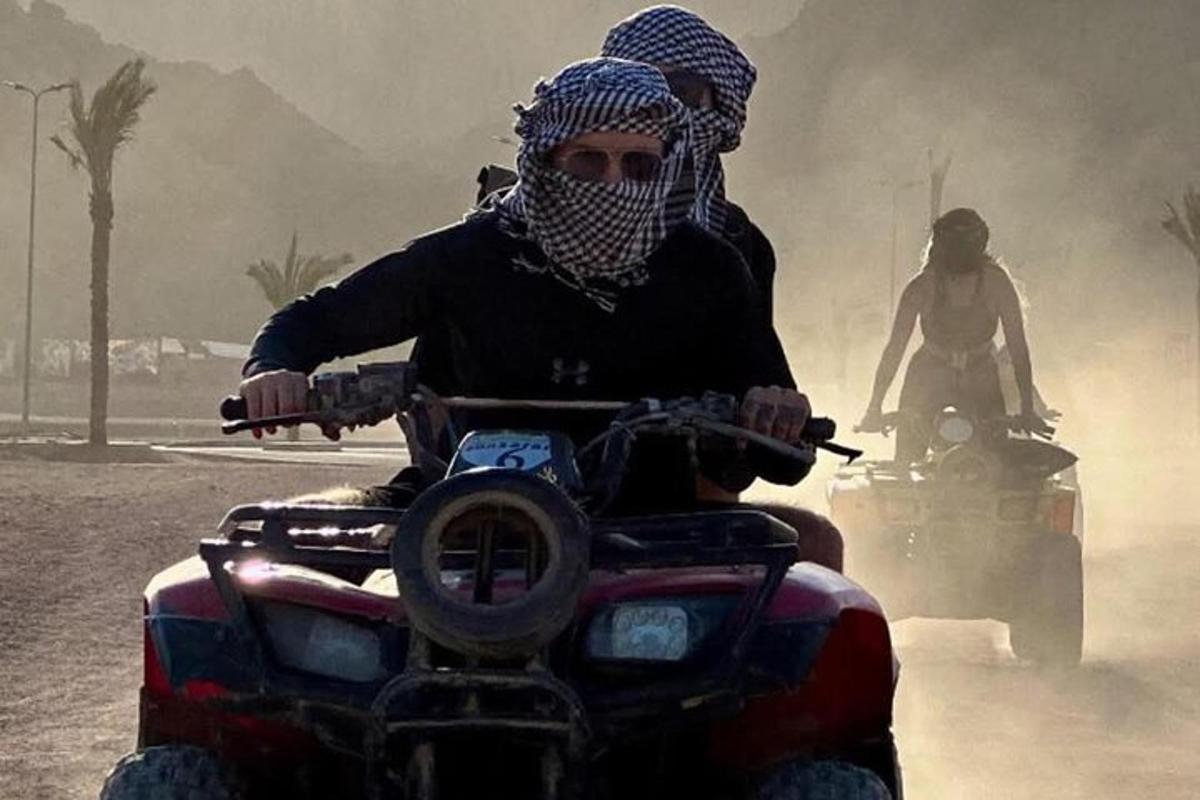 un uomo che guida un quad nel deserto