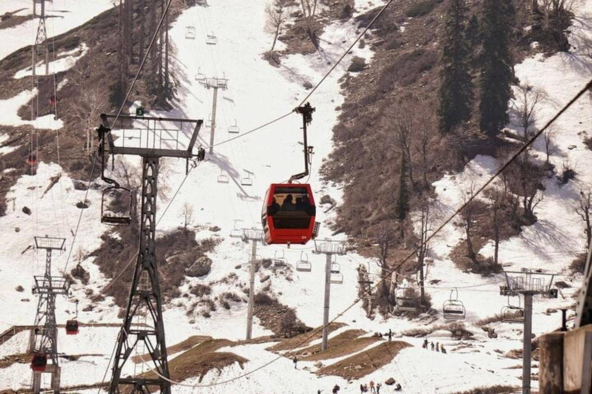 a red ski lift going up a snow covered mountain
