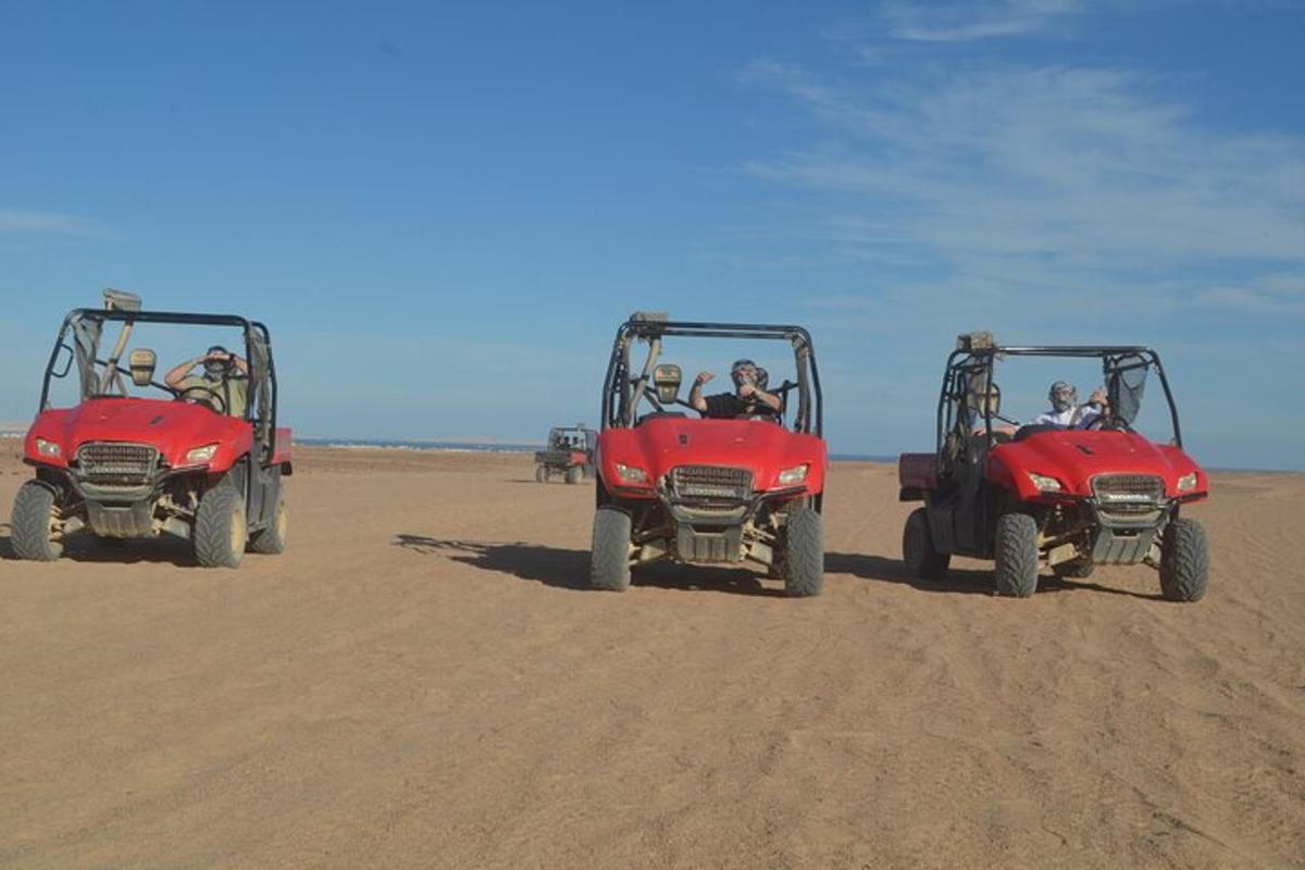tiga orang menaiki atv di pantai