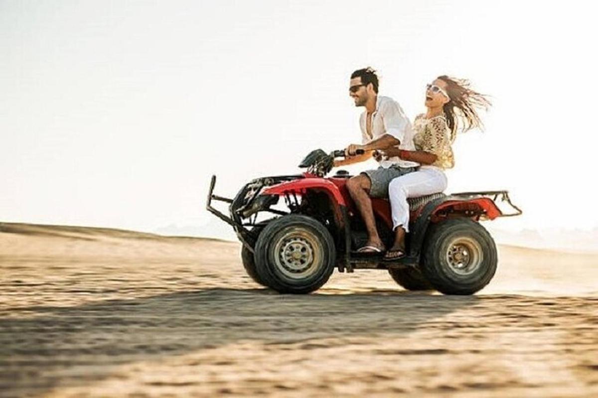 pasangan pengantin menunggang basikal quad di padang pasir