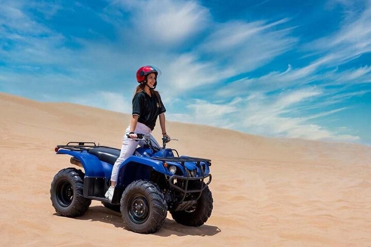seorang wanita berdiri di atas atv di padang pasir