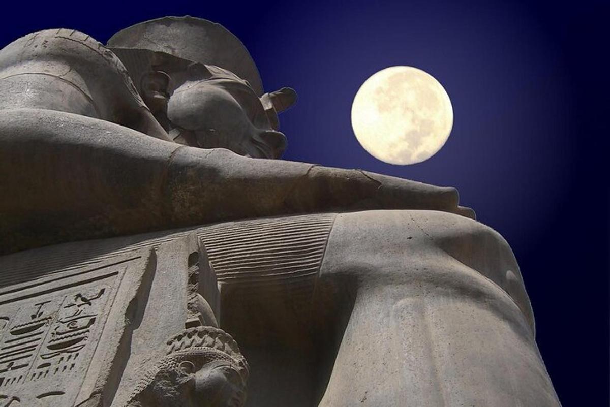 una gran estatua con la luna al fondo