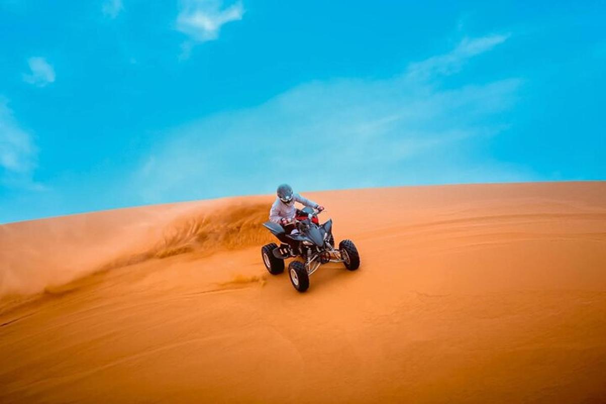 una persona conduciendo un quad en el desierto