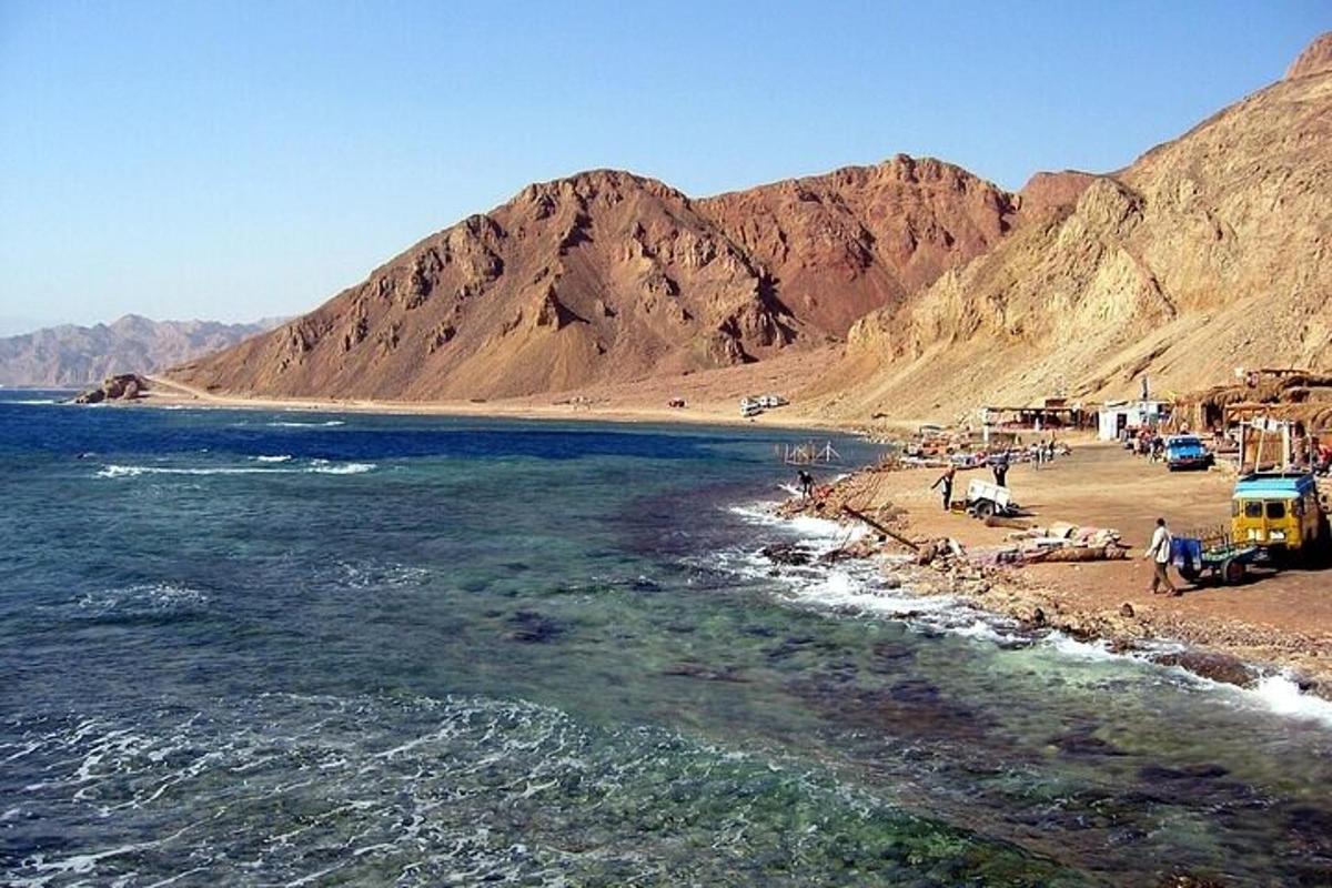 une plage avec un groupe de personnes et un bus