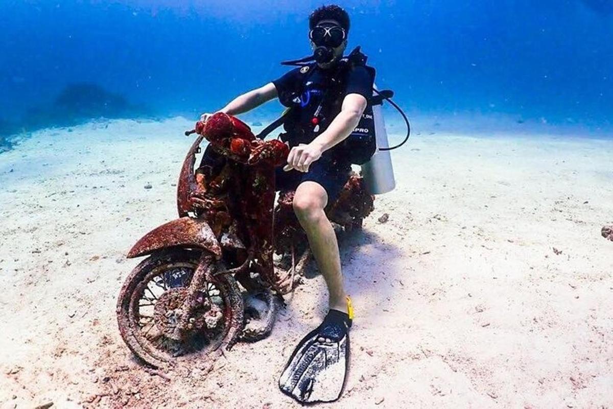 vyras sėdi ant motociklo smėlyje