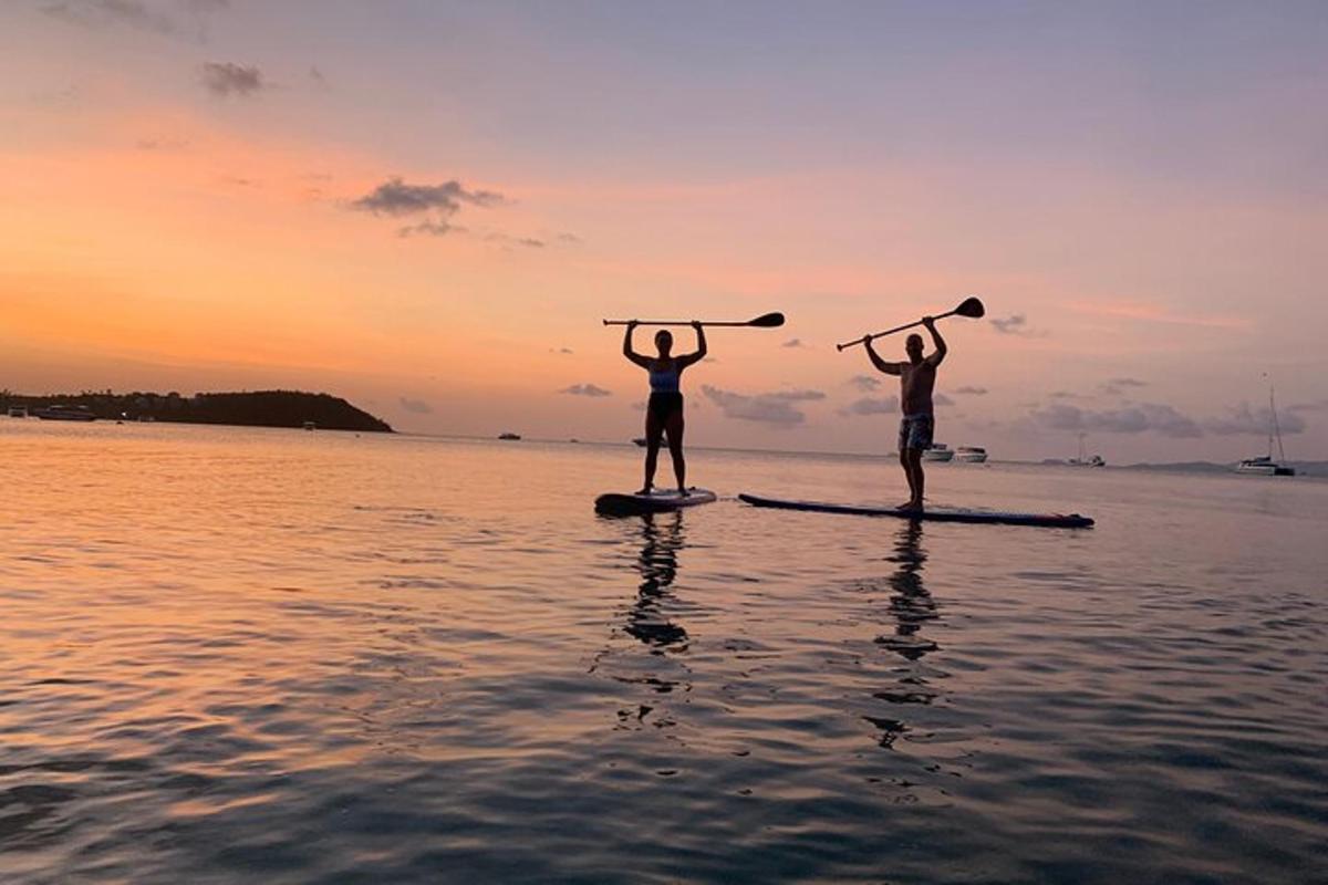 due persone in piedi su una tavola da paddle in acqua