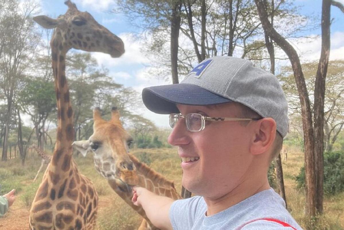 a man is standing in front of two giraffes