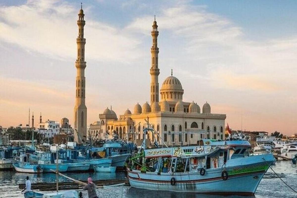 um grupo de barcos em um porto em frente a uma mesquita