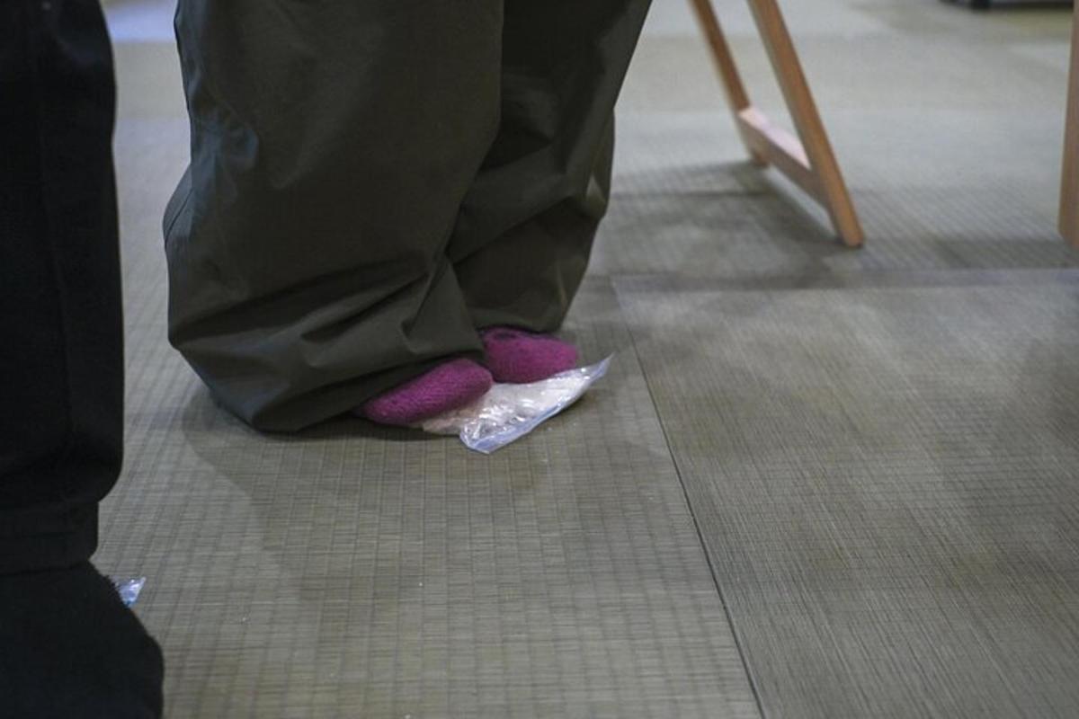 osoba s fialovými rukavicemi v rukavicích stojící na dlaždicové podlaze