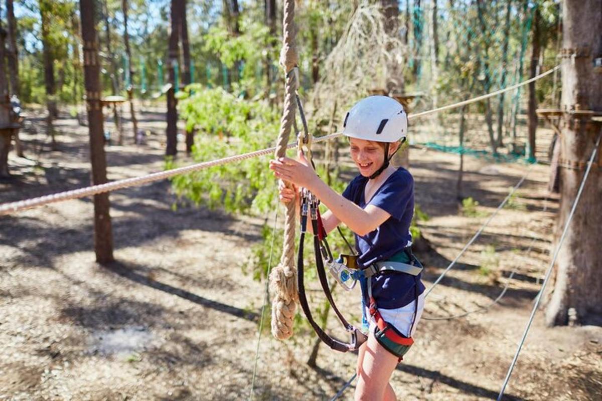 a young boy on a zip line in the woods