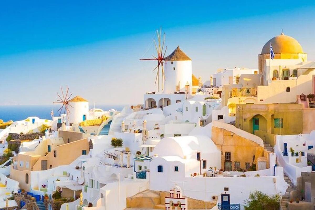 μια θέα ενός χωριού με λευκά κτίρια και έναν ανεμόμυλο