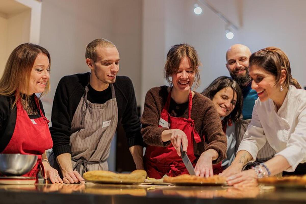 a group of people standing around a table making pizza