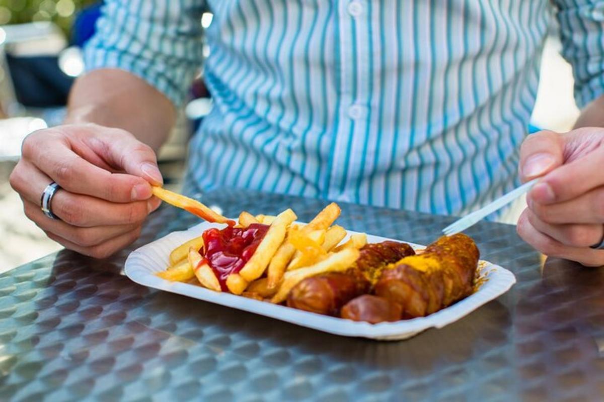 a person is eating a plate of food with french fries