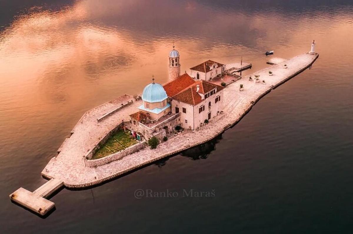 un'isola nell'acqua con un faro su di essa