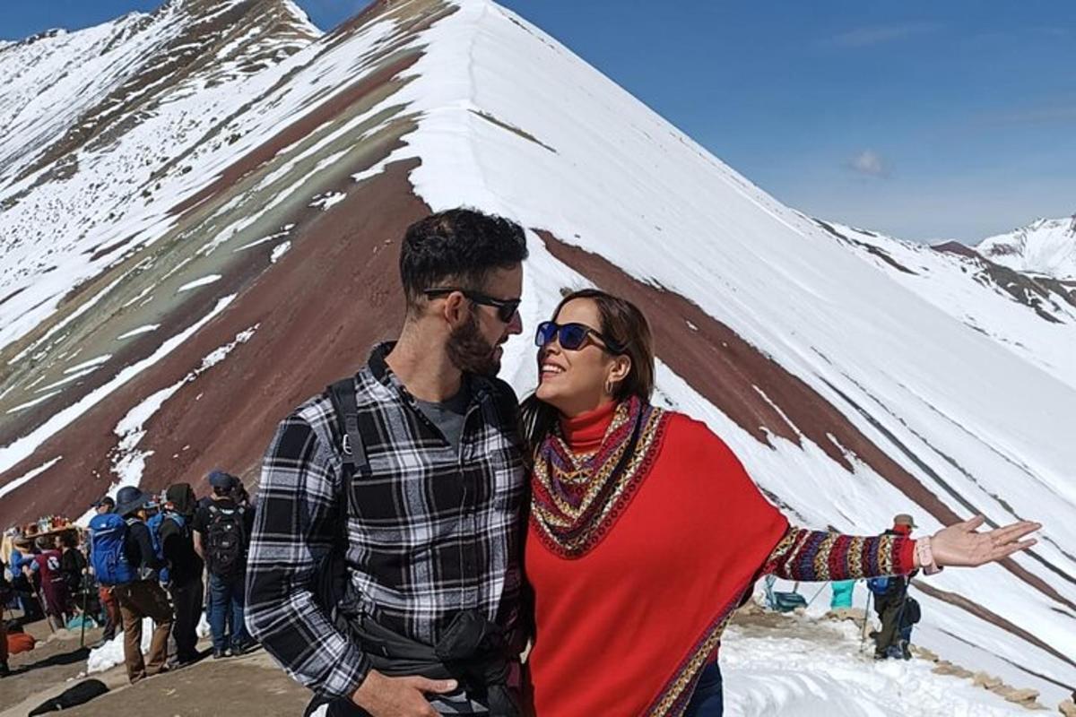 een man en een vrouw staan voor een met sneeuw bedekte berg