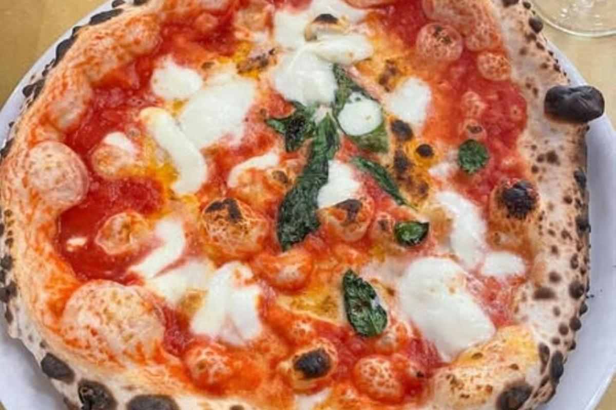 en pizza, der ligger på en tallerken på et bord