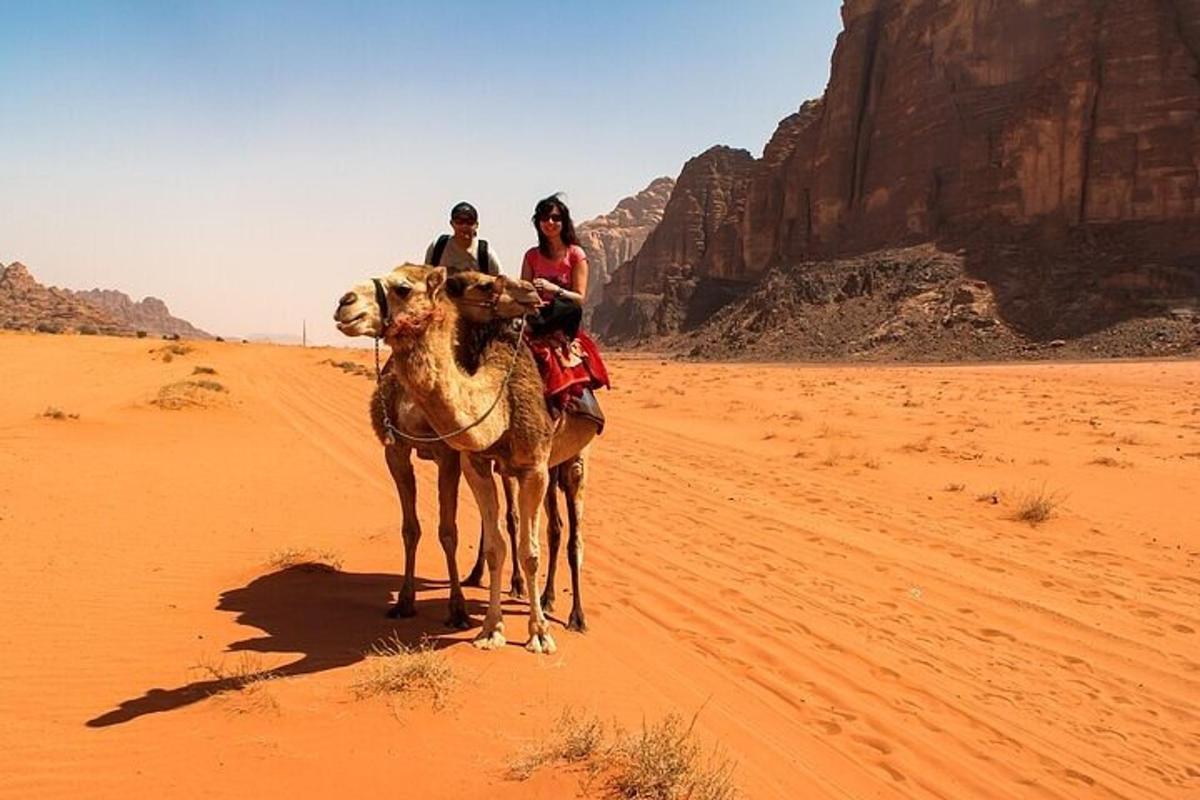 un grup de persones muntant un camell al desert