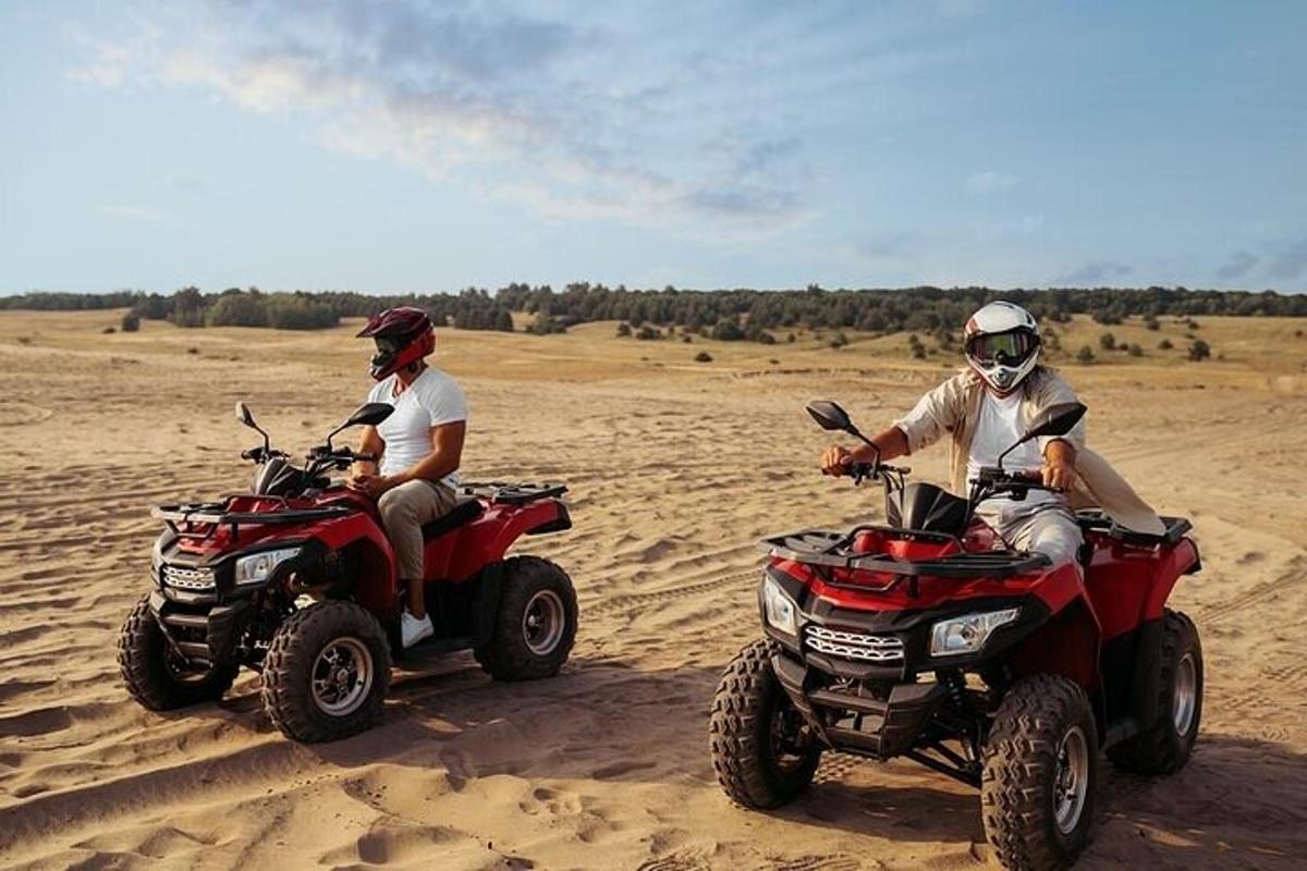 dos homes que condueixen quads al desert