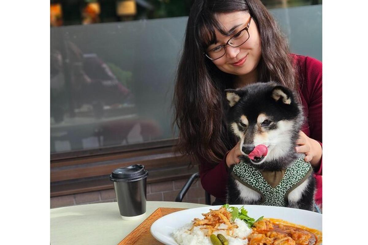 una dona que sosté un gos davant d'un plat de menjar