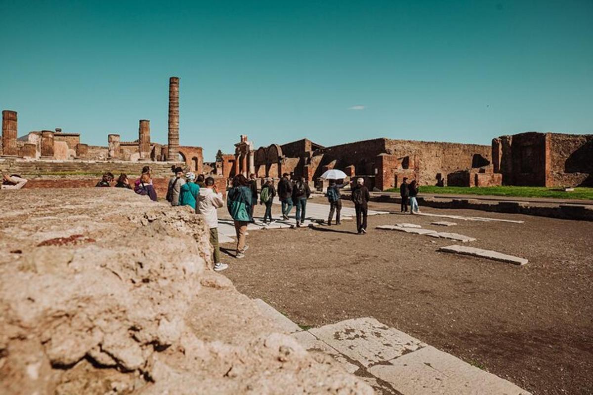 um grupo de pessoas caminhando ao redor de ruínas antigas