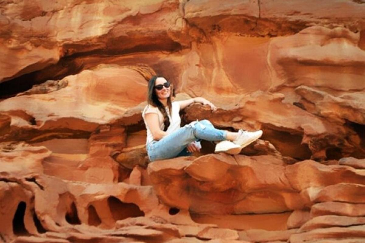 una donna seduta su una roccia in un canyon