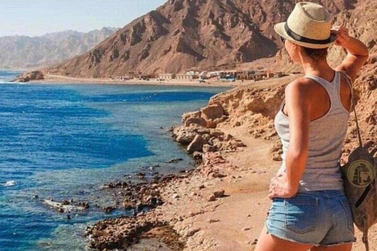 una donna in piedi su una scogliera che guarda l'oceano