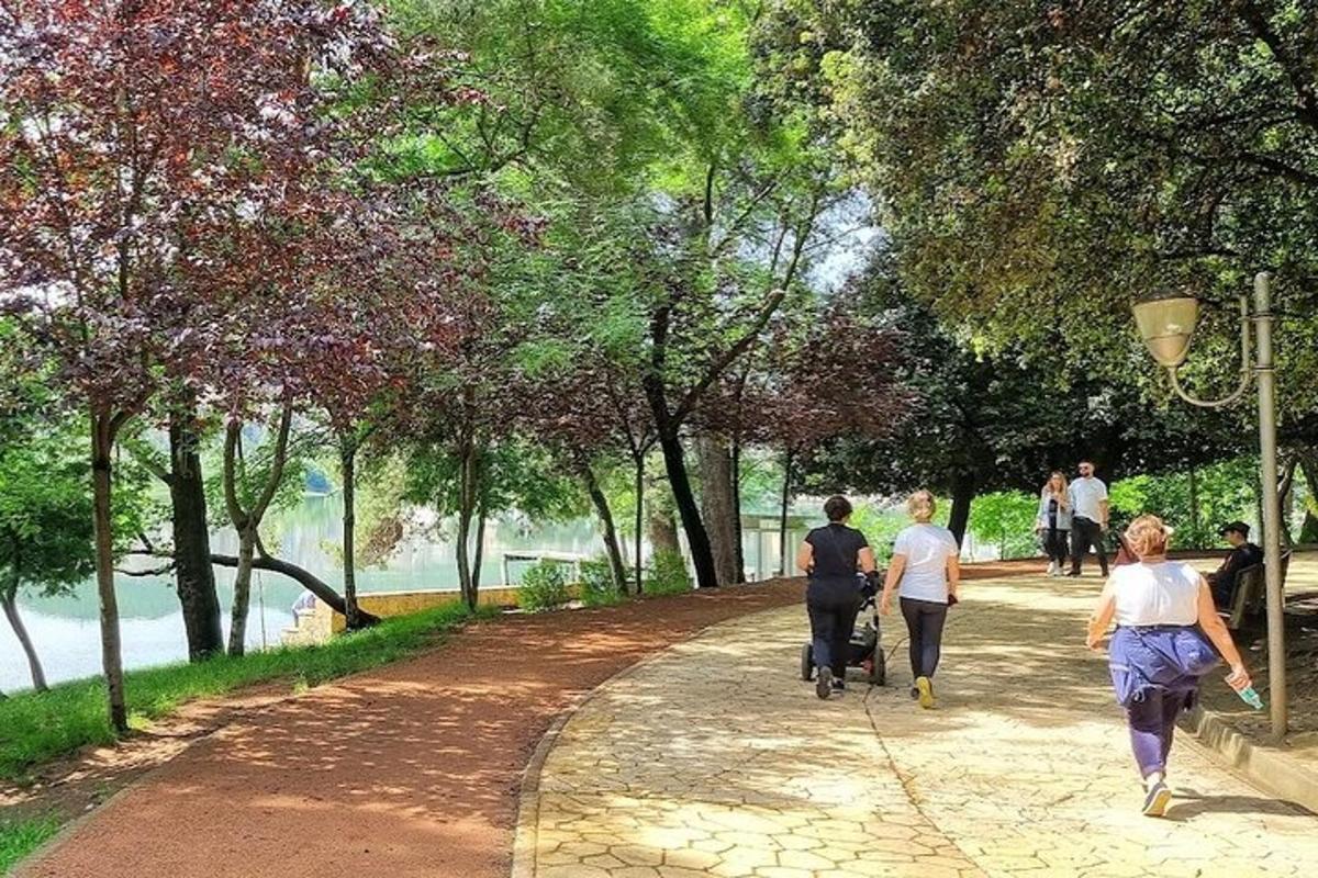 un grup de oameni care merg pe o alee într-un parc